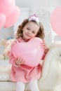 Cute six year old girl in pink dress with pink balloons in the shape of heart Royalty Free Stock Photo