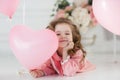 Cute six year old girl in pink dress with pink balloons in the shape of heart Royalty Free Stock Photo