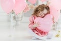 Cute six year old girl in pink dress with pink balloons in the shape of heart Royalty Free Stock Photo