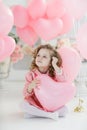 Cute six year old girl in pink dress with pink balloons in the shape of heart Royalty Free Stock Photo