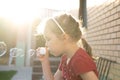 A little girl blowing soap bubbles in summer park. Royalty Free Stock Photo