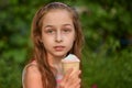 Little girl eat ice cream at an outdoor In a colorful striped bright dress. Sunny summer, hot weather Royalty Free Stock Photo