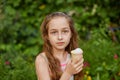 Little girl eat ice cream at an outdoor In a colorful striped bright dress. Sunny summer, hot weather Royalty Free Stock Photo