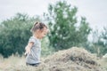 Little girl 3-4 years old jumps and plays in hay stack, throwing it up. Motion blur Royalty Free Stock Photo