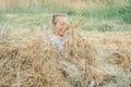 Little girl 3-4 years old jumps and plays in hay stack, throwing it up. Motion blur Royalty Free Stock Photo