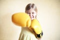 Little girl with yellow boxing gloves over yellow wall background