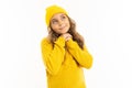 Little girl with in yellow hoody and hat dreams, portrait isolated on white background Royalty Free Stock Photo