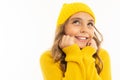 Little girl with in yellow hoody and hat dreams, portrait isolated on white background Royalty Free Stock Photo