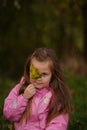 Little girl with yellow leaf. Child playing with autumn golden leaves. Kids play outdoors in the park. Children hiking Royalty Free Stock Photo