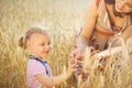 Little girl with young mother at grain wheat field Royalty Free Stock Photo