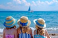 little girls in beautiful straw hats sit on the sand and look at the sea. girl friends are relaxing at sea. bright sunny day.