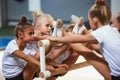 Little girls, beginner gymnastics athletes doing exercises with gymnastics equipment at sports gym, indoors. Concept of Royalty Free Stock Photo