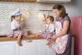 Little girls in chef hats with mother playing chefs. Concept family Royalty Free Stock Photo