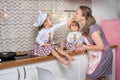 Little girls in chef hats with mother in apron is playing chefs. Royalty Free Stock Photo