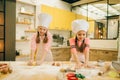 Little girls chefs crumple the dough, funny bakers Royalty Free Stock Photo