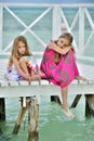Little girls in colorful dress on the white wooden pier Royalty Free Stock Photo