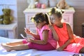 Little girls with curlers play with makeup accessories