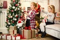 Little girls decorating Christmas tree and preparing gifts