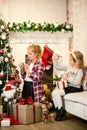 Little girls decorating Christmas tree and preparing gifts