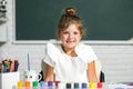 Little girls drawing a colorful pictures with pencil crayons in school classroom. Funny school girl face. Royalty Free Stock Photo