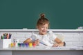 Little girls drawing a colorful pictures with pencil crayons in school classroom. Painting kids. Cute school girl