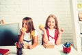 Little girls eat apple at lunch break. Back to school and home schooling. Friendship of small sisters in classroom at Royalty Free Stock Photo