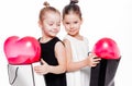 2 little girls with elegant dresses hold large bags with heart-shaped balloons inside Royalty Free Stock Photo