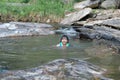Little girls enjoy swimming in the river. Cute Asian girl wearing a life jacket is having fun playing in the stream. Healthy Royalty Free Stock Photo