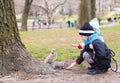 Little girls feeds a squirrel in Central park, New