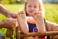 Little girls feet sitting in a wicker basket on a sunny day