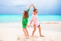 Little girls having fun at tropical beach playing together at shallow water. Adorable little sisters at beach during Royalty Free Stock Photo