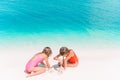 Two little happy girls have a lot of fun at tropical beach playing together Royalty Free Stock Photo