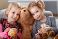 Little girls huddling up against teddy bear