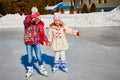 Little girls learn to skate. They are laughing and happy. Concept of friendship and fun holidays. Royalty Free Stock Photo