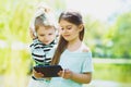 Little girls listening to music on headphones in a spring park outdoor Royalty Free Stock Photo