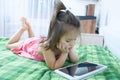 Little girls looking on pad lying on bed. Children time spending. Kids using tablet computer