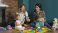 Little girls and they mams are playing with Colorful plastic bricks