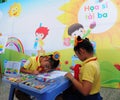 Little girls painting at the school in Saigon, Vietnam