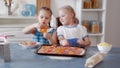 Little girls preparing pizza from ingredients