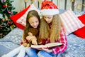 Little girls read book, Christmas time Royalty Free Stock Photo