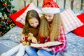 Little girls read book, Christmas time Royalty Free Stock Photo