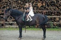 Little girls ride on horse on summer day. Equine therapy, recreation concept. Children smile in rider saddle on horse Royalty Free Stock Photo