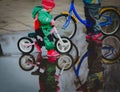 Kids riding bike in spring water puddle Royalty Free Stock Photo