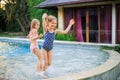 Little girls running in the swimming pool. Sisters playing together. Summer concept. Family activities. Happy childhood. Vacation