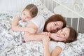 Little girls sick lying with mom in bed. stay home