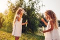 Little girls sisters blowing soap bubbles in spring park. Kids having fun playing games outdoors. Children activities Royalty Free Stock Photo