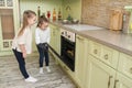 Little girls sisters looks at a tasty cookies in the oven