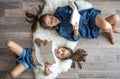 Little girls sisters read books lying on the floor, top view