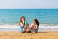 Little girls sit sit opposite each other and drink from colored beautiful cocktail glasses Family vacation concept Royalty Free Stock Photo