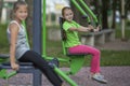 Little girls sitting on exercise equipment Royalty Free Stock Photo